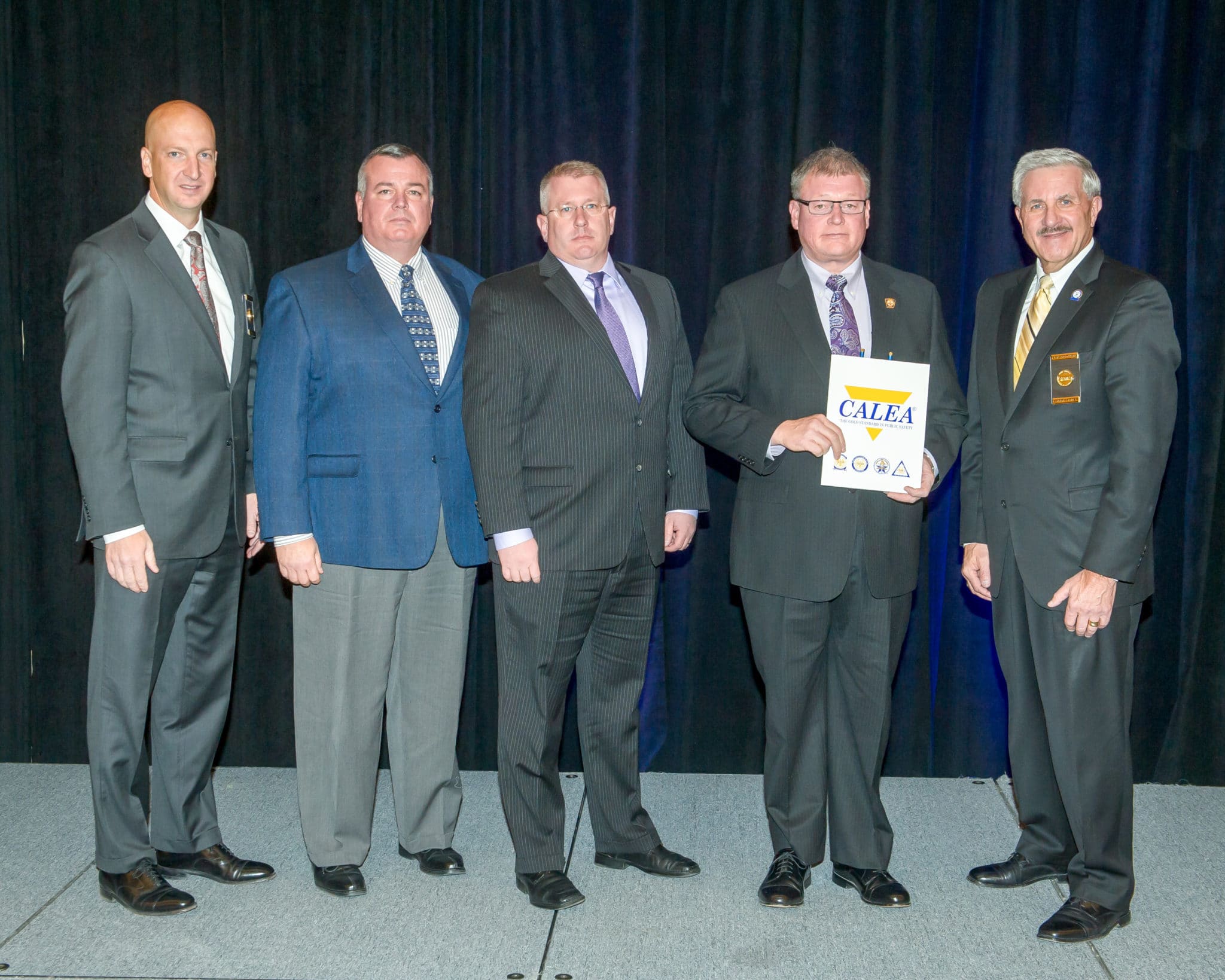 Danvers Police Captain Patrick Ambrose (second from left), Lieutenant/Accreditation Manager James Lovell (middle), and Chief Neil Ouellette (second from right) receive the CALEA Re-Accreditation Award from CALEA officials. Pictured are Executive Director W. Craig Hartley Jr. (Left) and Commission Chairman J. Grayson Robinson (right). (Courtesy of the Danvers Police Department)