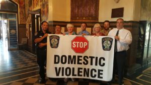 Gloucester officials appointed their first Domestic Violence Police Officer today. Left to right, Officer George Carr, Mayor Sefatia Romeo Theken, Sunny Robinson, Co-Chair of the Gloucester Coalition for the Prevention of Domestic Abuse, Officer Ronald Piscitello, Nicole Richon-Schoel, Co-Chair of the Gloucester Coalition for the Prevention of Domestic Abuse, Ross Steinborn, Education and Outreach Specialist from the North Shore Rape Crisis Center, and Police Chief Leonard Campanello.